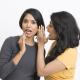 Women whispering a secret