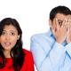 Man hiding his face and woman surprised