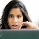 Shocked woman looking at her laptop screen